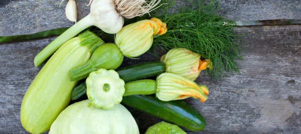 Different varieties of squash and zucchini on wood table