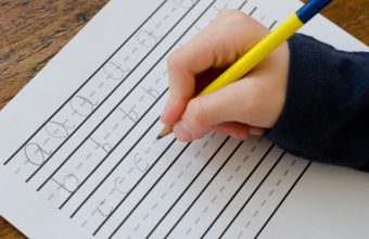 Child practising writing their letters abc