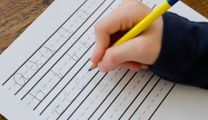 Child practising writing their letters abc